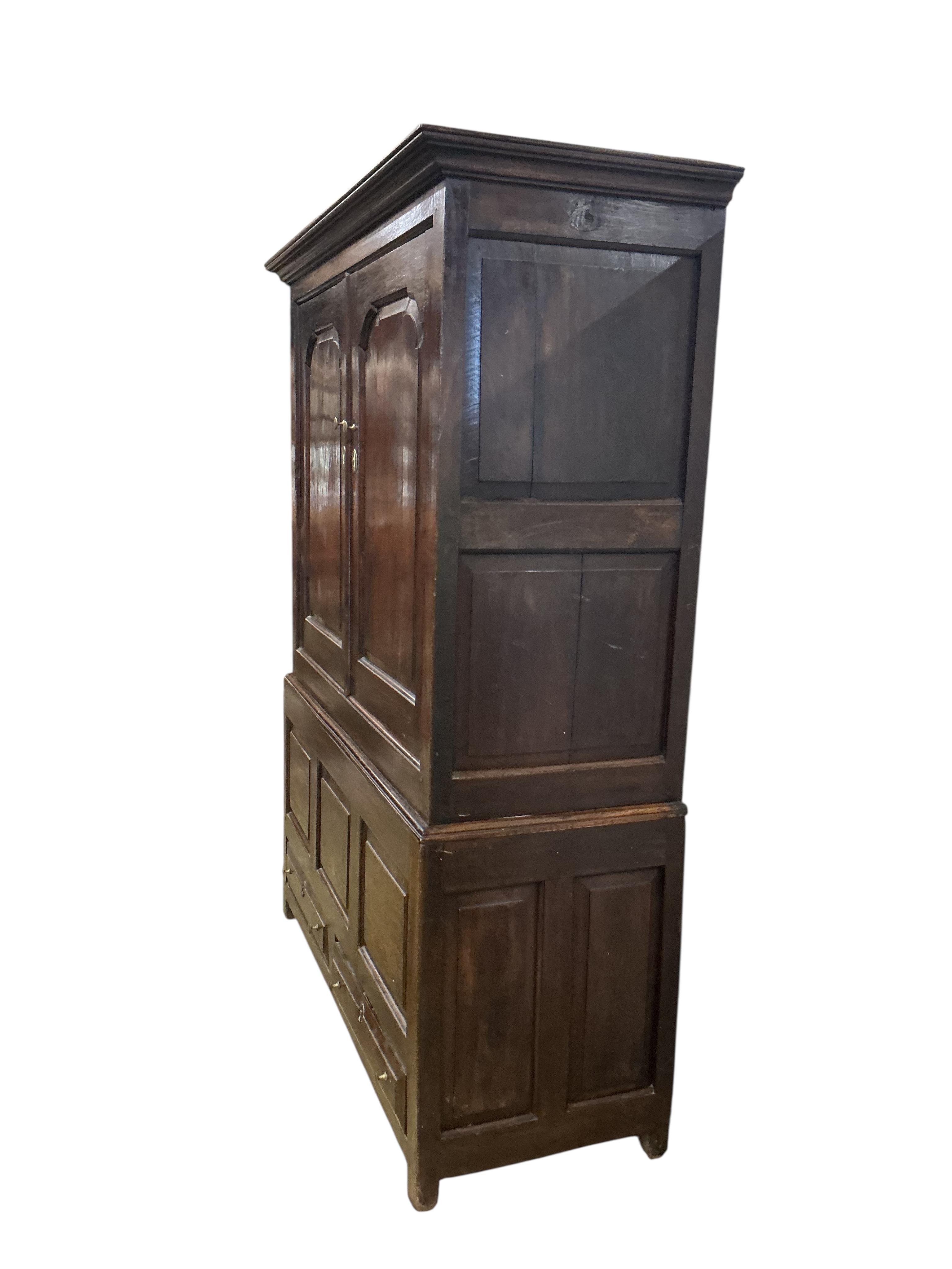 An 18th century oak two part hanging cupboard, width 139cm, depth 55cm, height 181cm